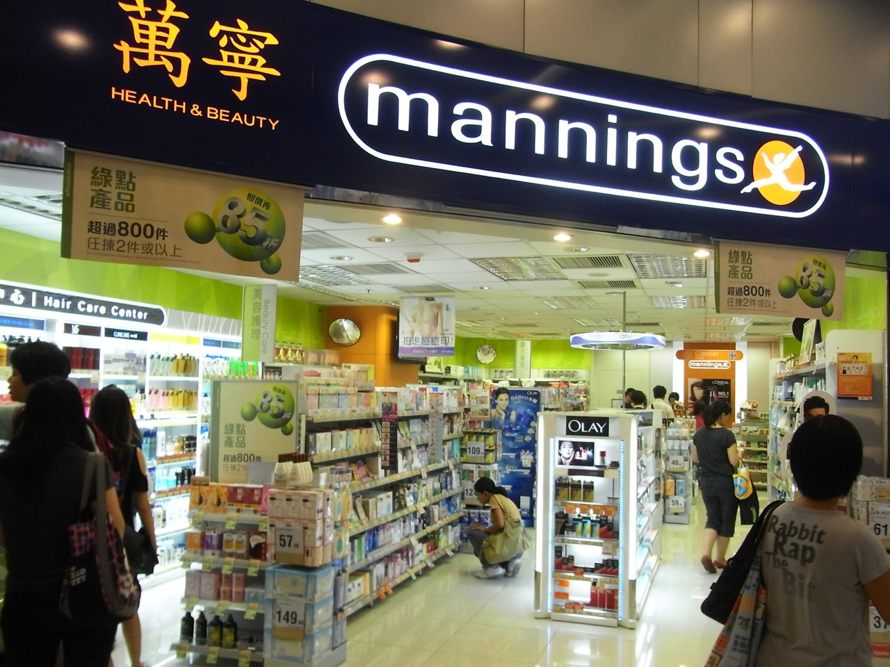 Historic Mannings shop entrance and illuminated bilingual sign at Hing Wah Plaza. No customer health situation or present-day condition is inferred.